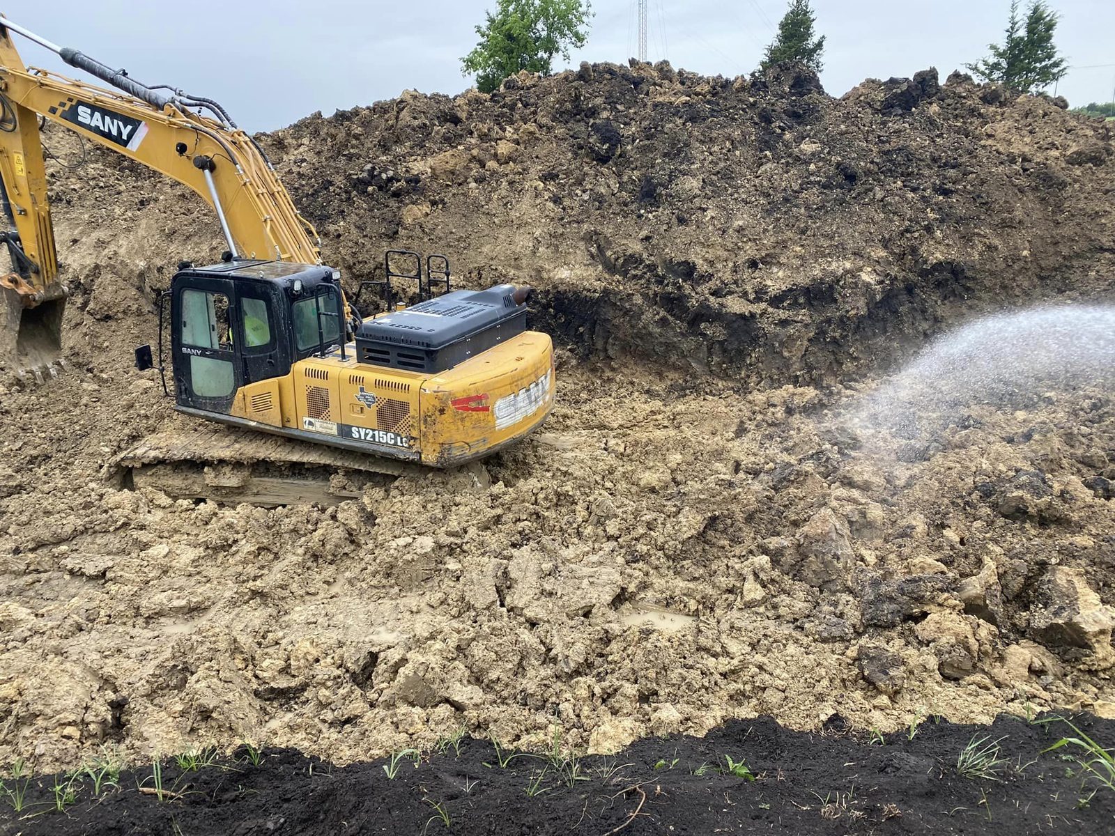 Excavator moving earth on a North Texas job site